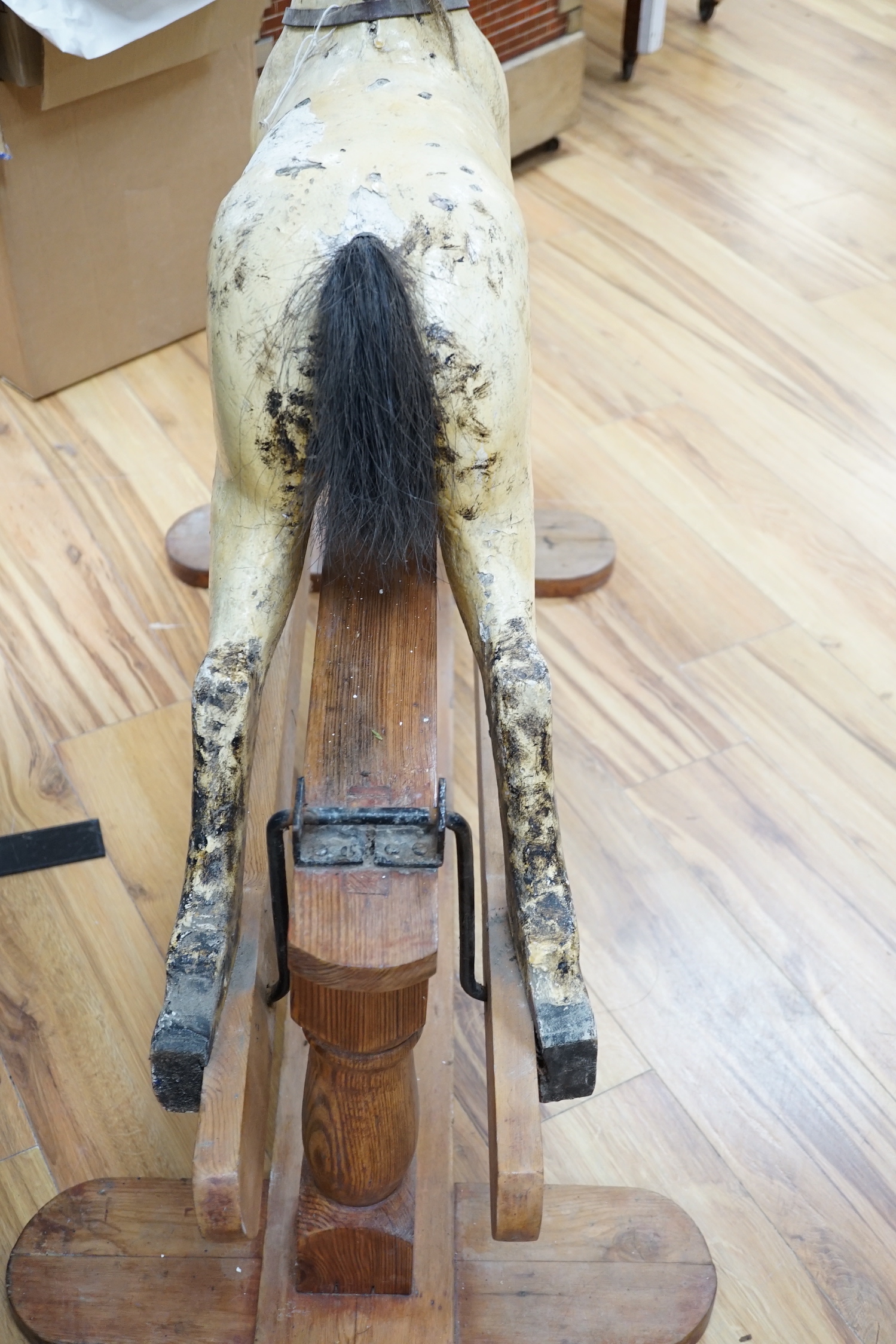 A Rocking horse on a wooden pedestal rocker, with plaster, composite body, height, 97cm, length 152cm